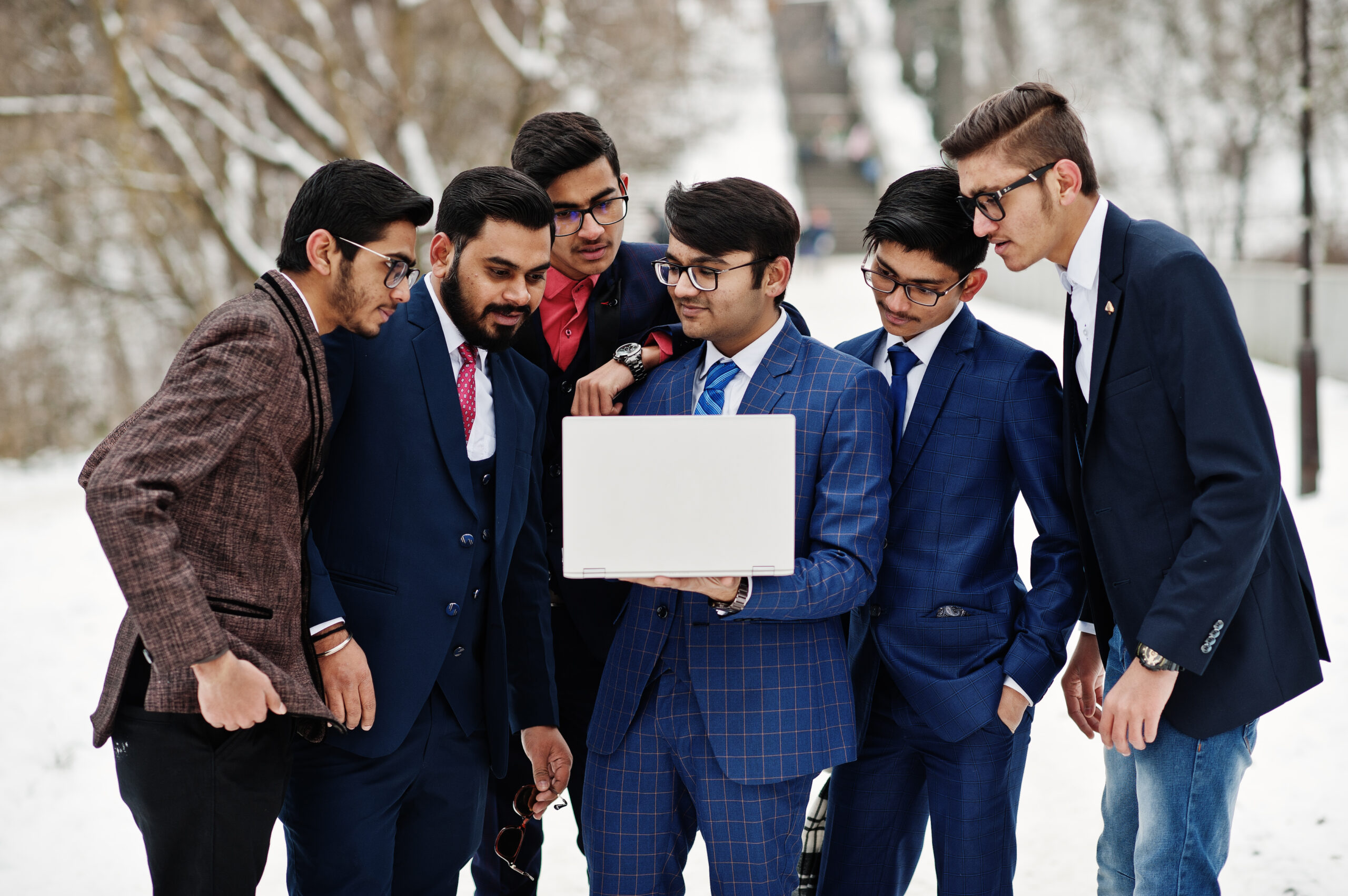 Group of six indian businessman in suits posed outdoor in winter
